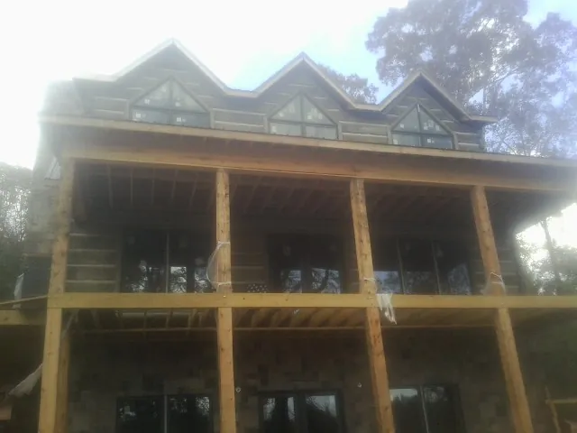 Dormers and porch framing on a large log home under construction — Roof Coating work by our crew in El Monte